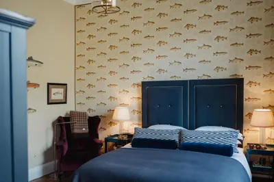 a bedroom with a bed with a blue headboard and a wall at Private and Prestigious Luxury Home in Edinburgh