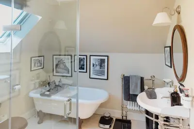 a bathroom with a sink and a mirror and a tub at Private and Prestigious Luxury Home in Edinburgh