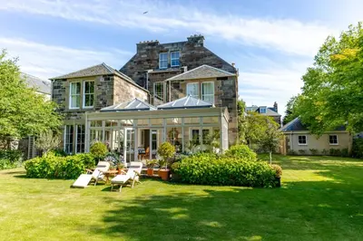 a house with a conservatory with a lawn at Private and Prestigious Luxury Home in Edinburgh