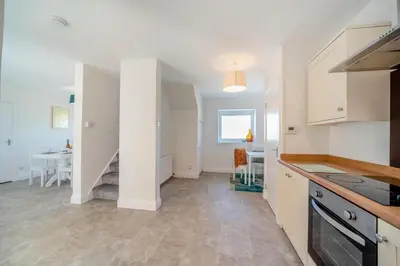 a kitchen with white cabinets and a dining room at 3 Bed in Leswalt oc-g32241 in Leswalt