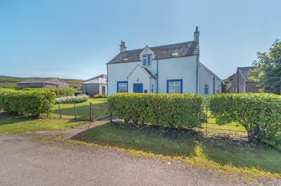 a white house with bushes in front of it at 3 Bed in Clachan oc-h32242 in Clachan