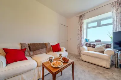 a living room with a white couch and red pillows at 3 Bed in Clachan oc-h32242 in Clachan