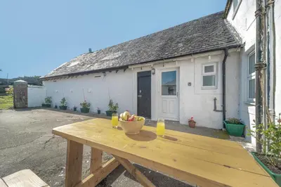 a wooden table with a bowl of fruit and two glasses at 3 Bed in Clachan oc-h32242 in Clachan
