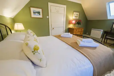 a bedroom with a white bed with two towels on it at Craigendarroch No 1 in Acharn