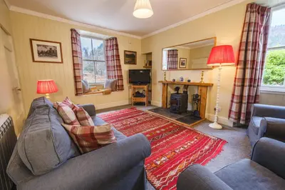 a living room with a couch and a television at Craigendarroch No 1 in Acharn