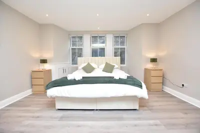 a bedroom with a large bed with two night stands at The Cliff Retreat in Wemyss Bay