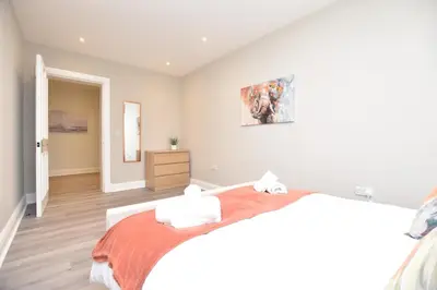 a bedroom with a bed and a painting on the wall at The Cliff Retreat in Wemyss Bay