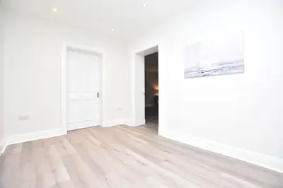 an empty room with white walls and wooden floors at The Cliff Retreat in Wemyss Bay