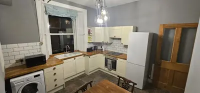 a kitchen with a sink and a washer and dryer at Cosy 2 bedroom flat-castle view in Edinburgh