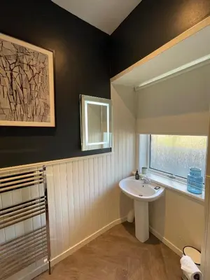 a bathroom with a white sink and a window at The Shore House in Lochgoilhead