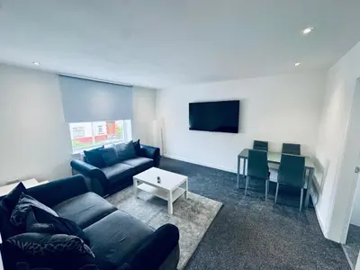 a living room with a couch and a table at Modern 2 Bedroom with extra Loft Bedroom in Glasgow