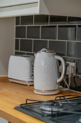 a white toaster sitting on top of a kitchen counter at Clydebank 2 Bedroom Home in Drumchapel