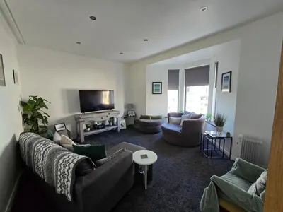 a living room with couches and a flat screen tv at Central Portrush Townhouse available for Open Golf in Moffat