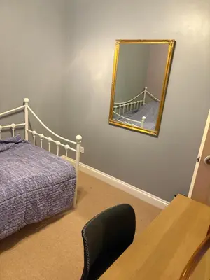 a bedroom with a bed and a mirror on the wall at Single Room in Moffat
