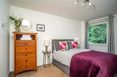 a bedroom with a bed and a dresser and a window at Edinburgh Pad in Edinburgh