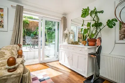 a man in a suit standing in a living room at Edinburgh Pad in Edinburgh
