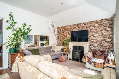 a living room with a couch and a stone fireplace at Edinburgh Pad in Edinburgh