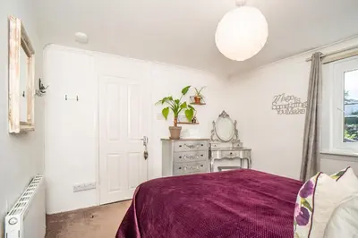 a bedroom with a bed with a purple blanket at Edinburgh Pad in Edinburgh