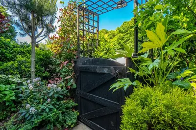 an open gate in a garden with plants at Edinburgh Pad in Edinburgh