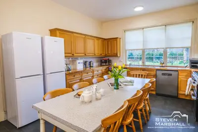 a kitchen with a table and a white refrigerator at Achranich House in Lochaline