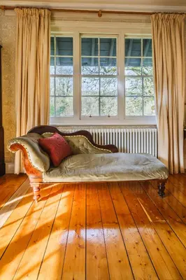 a large couch sitting in a room with windows at Achranich House in Lochaline