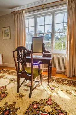 a living room with a piano and a chair at Achranich House in Lochaline
