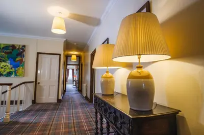 two lamps on a table in a hallway at Achranich House in Lochaline