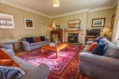 a living room with two couches and a fireplace at Achranich House in Lochaline