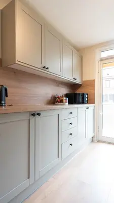 a kitchen with white cabinets and a window at Tummel Place in Grangemouth