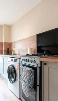 a kitchen with a stove and a washing machine at Tummel Place in Grangemouth