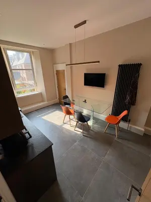 a living room with a glass table and chairs at Spacious 2 Bed Edinburgh - Perfect Location in Edinburgh