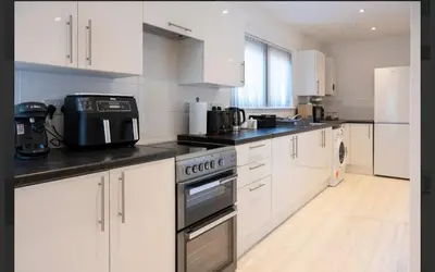 a kitchen with white cabinets and a stove top oven at Central Mews Free Wi-Fi-Parking-Contractors in Newton Stewart