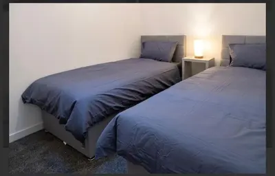 two beds sitting next to each other in a bedroom at Central Mews Free Wi-Fi-Parking-Contractors in Newton Stewart