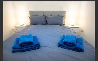 a bed with blue towels on top of it at Central Mews Free Wi-Fi-Parking-Contractors in Newton Stewart