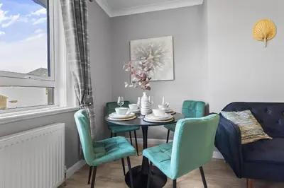 a dining room with a table and chairs at Welcoming Home in Hurlford, Kilmarnock - Bonnie Lodgings in Hurlford