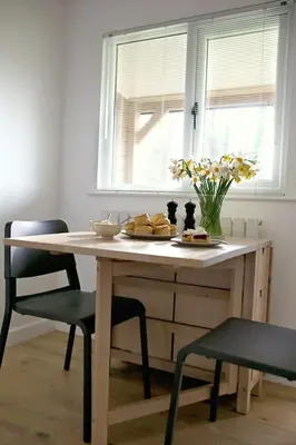 a table with a plate of food and flowers on it at Newly built luxury cabin in Moffat