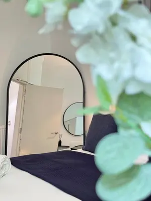 a bedroom with a bed and a mirror at Cosy City Centre Apartment in Edinburgh