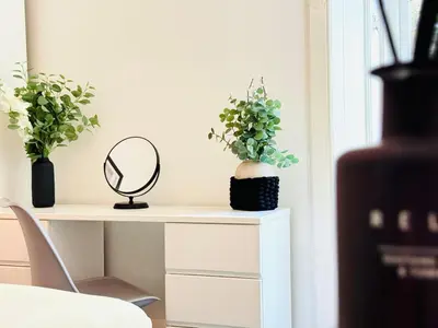 a white table with a mirror and plants on it at Cosy City Centre Apartment in Edinburgh