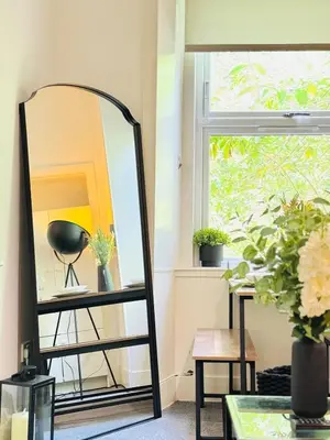 a mirror on a shelf next to a window at Cosy City Centre Apartment in Edinburgh