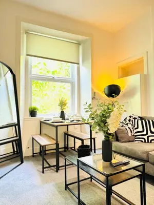 a living room with a couch and a table at Cosy City Centre Apartment in Edinburgh