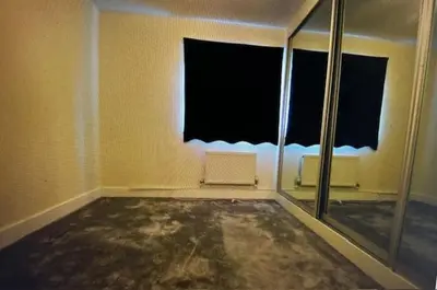 an empty room with a window and a mirror at Grebe House in Moffat