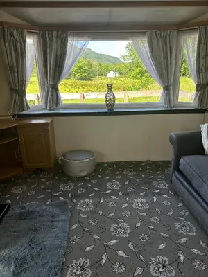 a living room with a couch and a window at 77 Glenfinart Caravan Park in Dunoon