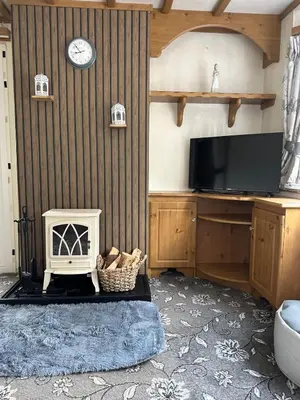 a living room with a fireplace and a tv at 77 Glenfinart Caravan Park in Dunoon