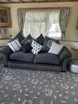 a blue couch in a living room with a window at 77 Glenfinart Caravan Park in Dunoon