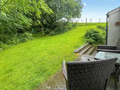 a patio with a table and chairs in a yard at Professors Cottage in Girvan