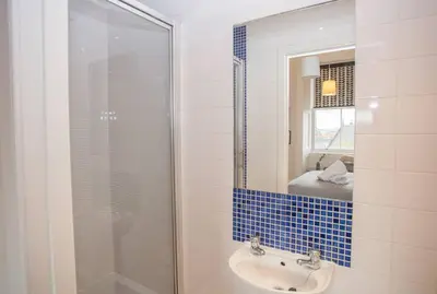 a bathroom with a sink and a glass shower at Spacious Period Property in Glasgow in Glasgow