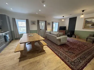 a living room with a table and a couch at Altchourunn Cottage in Acharra