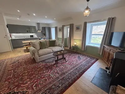 a living room with a couch and a rug at Altchourunn Cottage in Acharra