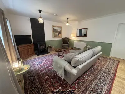 a living room with a couch and a television at Altchourunn Cottage in Acharra