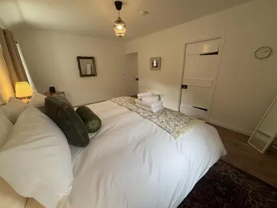 a bedroom with a large white bed with pillows at Altchourunn Cottage in Acharra
